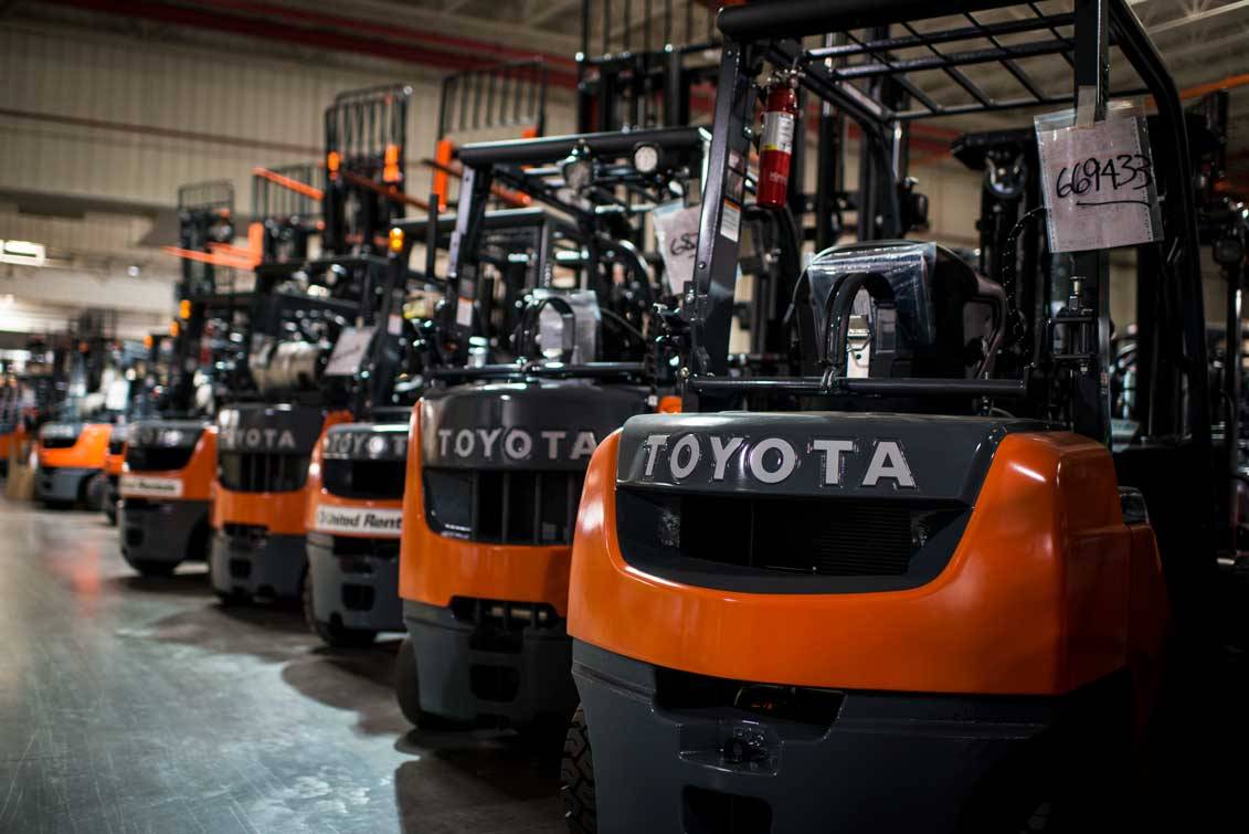 A row of Toyota forklifts in a showroom.
